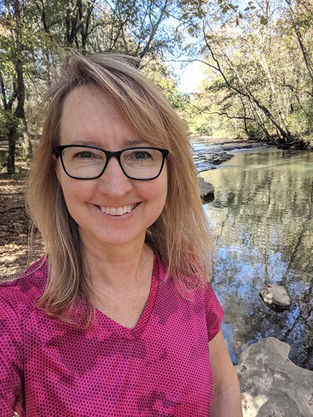 Jackie in pink T with creek in background