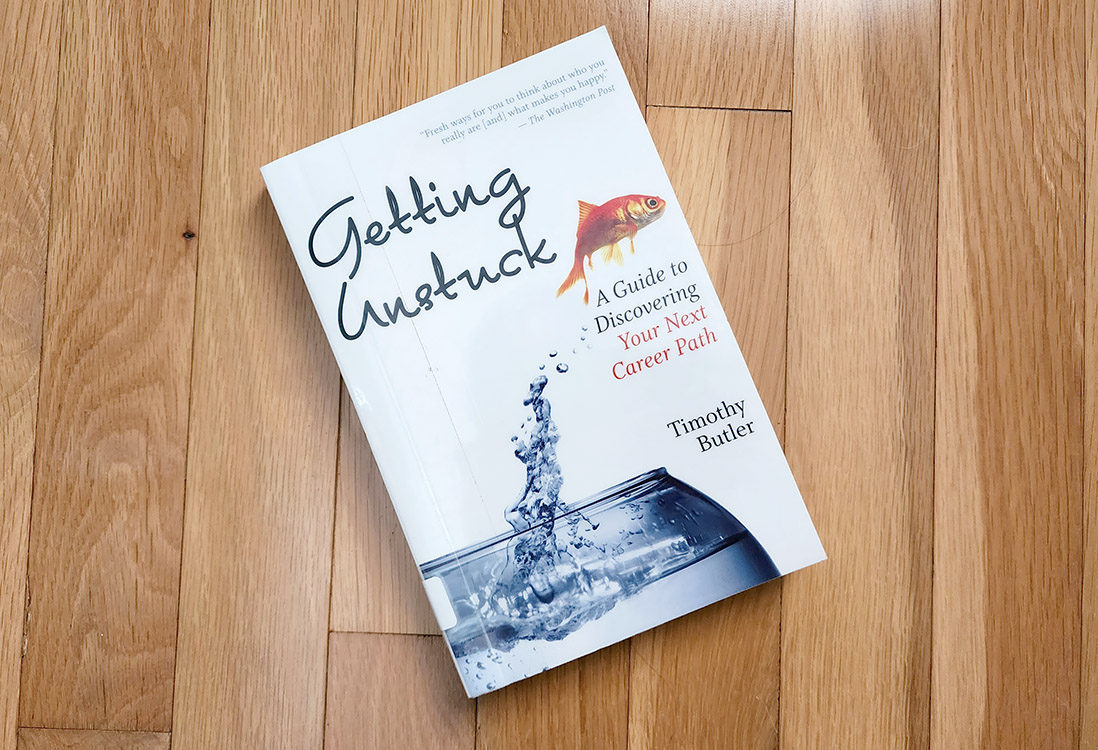 The book titled "Getting Unstuck" laying on a hardwood floor